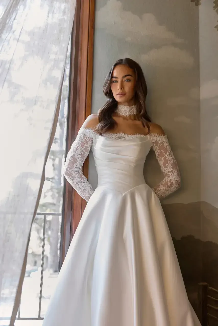 model is wearing a long sleeve bridal gown from essense of australia