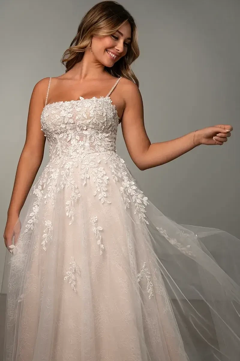 Model is wearing an A-line lace gown with a square neckline and full-length skirt.