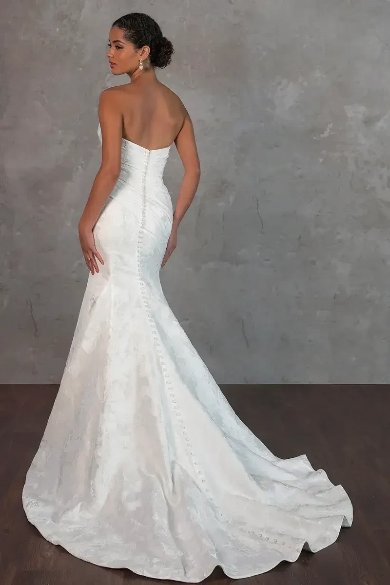 Model is wearing a satin fit-and-flare wedding dress with a sweetheart neckline and sleek, modern silhouette.