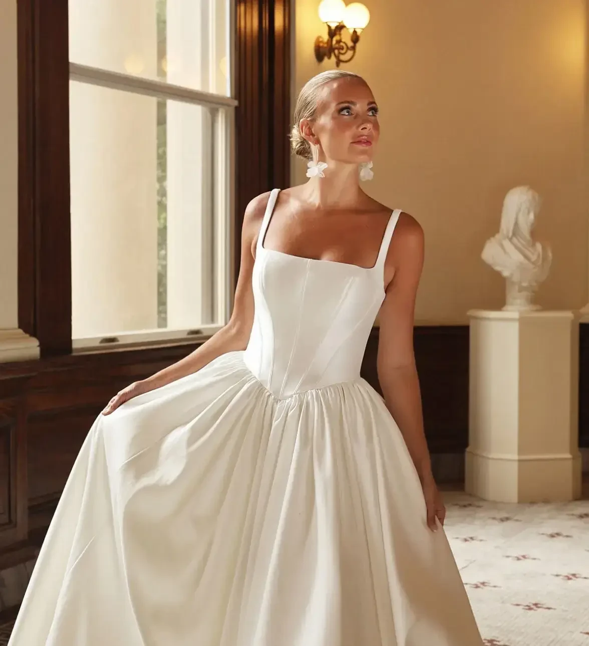 Photo of model wearing white gown with square neckline
